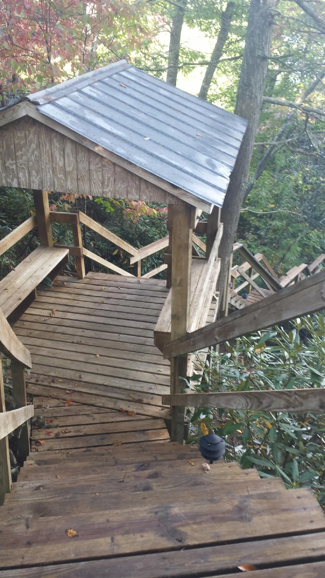 Metal roofed shelter over wooden steps on a wooded walkway — Skylight Repair & Installation work by our crew in Wells