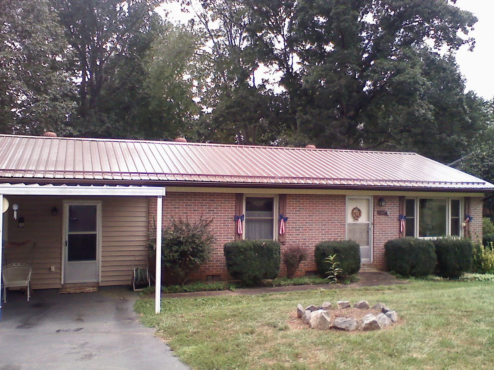 Bronze metal roof and carport on a brick ranch home — Roof Repair work by our crew in Wells